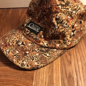 Chuck keps - Chuck keps, Jaguar mönstrad. Knappt använd då den är för stor för mig. 