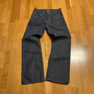 Baggy bootcut jeans med fet textur. Mörk gråblå färg som sitter lite flared o går lätt över skorna. Skriv för frågor mm 100cm längd, 38.5 i bredd och 23.5cm i benöppningen.