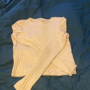 Kroppad ribbad beige långärmadtröja - Använd en gång, jättefint skick. Ganska liten pga att den är kroppad. Snygg till svarta eller blå byxor.