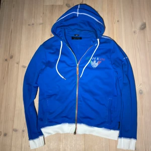 Armani special edition zip-hoodie  - En väldigt snygg och unik Armani tröja, storleken är XXL men passar mig som är M och passar även S. Säljer pågrund av att jag inte hittat användning för den. Finns små slitage här och där, främst på trycket . Annars är den i superskick.