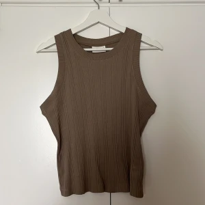 Ribbat linne Gina - Beige/grått ribbat linne från Gina Tricot, strl L. Användt fåtal gånger, passar bra med kavaj över!