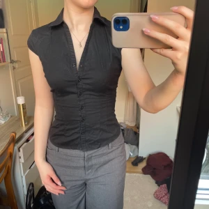 Kortärmad skjorta - Svart kortärmad skjorta som sitter smickrande och är väldigt tajt i passformen. Insydd i ryggen men går att ta bort. 