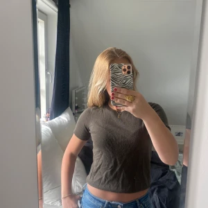 Stickad t-shirt - Bra skick, lite nopprig (men inget som syns tydligt), i grön/brun färg(oliv).