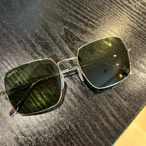 Stora fyrkantiga solglasögon från Gucci. Guldiga med grönt glas, säljer pga. Förstora för mig. Inga repor i glasen och knappt använda. Köpta på Synsam, ord pris 2500kr. Fodral medföljer