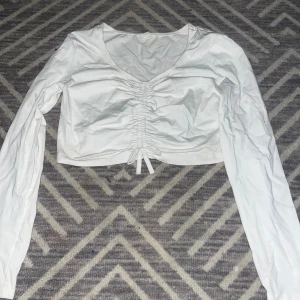 Vit fin magtröja - En vit fin magtröja. Men en fin roset på, helt vit bak också.