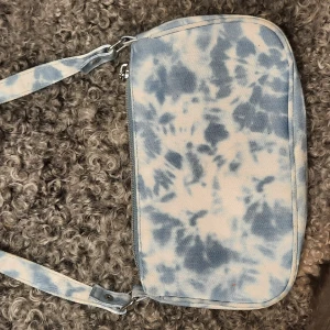 Handväska - Handväska i batikmönster vit/blå. Mycket fint skick. Mått 23x14 cm, axelband 45 cm. Pris inkl. frakt. 