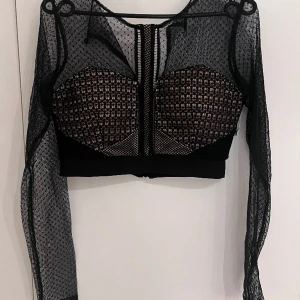 Kort tipp med genomskinlig nät armar - Topp är i bra skick och använts en gång. Av plyester
