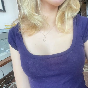 Lila T-shirt med låg rygg - Säljer denna T-shirt med låg rygg i lila som man kan ha bak och fram för en djupare urringning som på bild 1! Jättefin passform