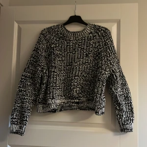 Stickad tröja  - En croppad svart och vit stickad tröja. Rätt så kort i ärmarna, brukade använda som trekvartslånga.  