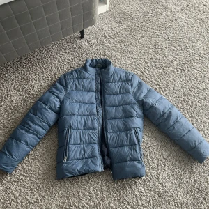 Ljus blå dun jacka knappt använd  - Bra skick, använd 2-3 gånger, säljer för den var för liten och behöver pengar. Exsklusive frakt