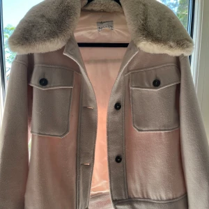 Snygg kappa med pälskrage - Snygg kappa med pälskrage som man kan ta bort. Fint skick men man kan se att den är använd. Den är köpt från noella.