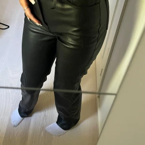 Skinnbyxor (imitation) från bikbok - Säljer dessa svarta skinn/läder imitation byxor från bikbok. INTE äkta skinn. Svarta, storlek 34. Inte andvända så mycket men som bilden visar, där man sätter bältet, en av dessa är av.