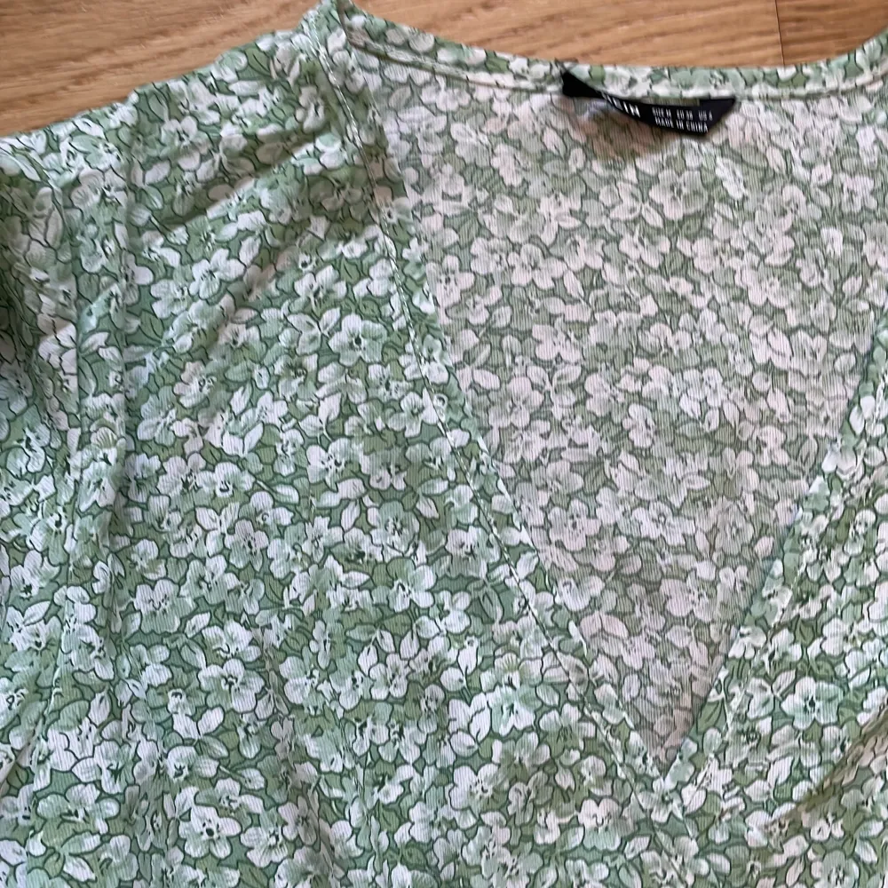 En grönblommig klänning med v-ringning från Shein i storlek M. Jag säljer eftersom att jag inte passar i den.. Klänningar.