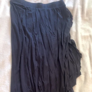 Volang kjol - Svart kjol med volang effekt på sidorna / slit längst benet. (OBS: Söndrig kamera därav de suddiga bilderna)