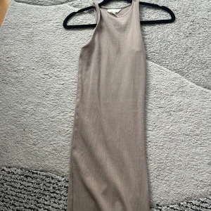 En lång klänning  - Den är 77cm lång och den är elastisk så den kan bli ganska bred. Det är en lång sommarklänning i färgen beige. Den är i super bra skick.