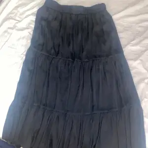 en svart maxi kjol som är utsvängd och bra för sommaren att ha