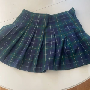Grönblå-rutig kjol - Grönblå kjol med rutmönster. Väldigt fin till en marinblå tröja