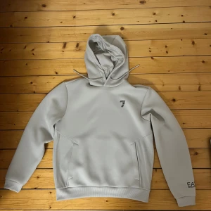 Emporio armani hoodie - Ljus grå emporio armani hoodie med oversized fit. Storleken är S men passar även till M. 100% äkta köpt i italien. Extremt bra skick. Har bara använts ett fåtal gånger. Originalpris 1300:-. Pm för mer info och bilder. Pris kan diskuteras. 