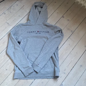 Tommy Hilfiger Hoodie - Tja, säljer min gråa Tommy Hilfiger tröja då den blivit för liten. Hör av er för fler frågor. 