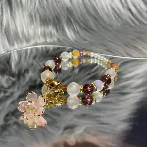 16cm, handgjort armband med handgjord special designad berlock av en sakura blomma med en swarovski (superglittrig) kristall✨glas/akryl pärlor av högkvalitet. Vid frågor kontakta mig annars ”köp nu” 🥰✨💫