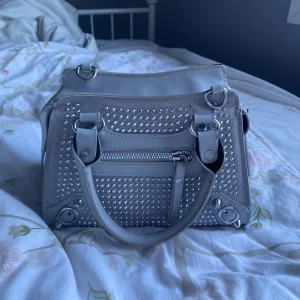 Grå nit väska  - Grå nitväska som är i jättebra skick, kommer ej till användning för mig tyvärr☺️