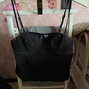 Svart struktur linne💫🖤 - Säljer detta ur-snygga struktursydda linnet från Hm. Toppen är i stl 36 och är endast använt ett fåtal gånger!🤩Det modellen påminner om en korsett men är mer stretchig.🫶🏻 Små vita fläckar som säkerligen går bort i tvätten, därav priset.💫