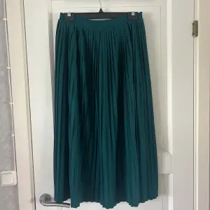 Grön plisserad midikjol i storlek S från NA-KD. Endast använd en gång så därav kvalitet som ny. Köparen står för frakten!!💚💚