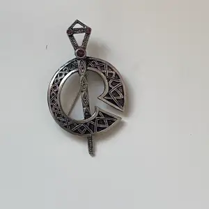 Fin brosch keltiskt svärd med lila stenar  Okänt material 