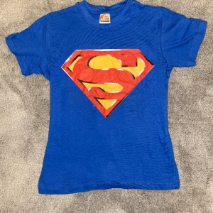 Super man T-shirt❤️💙 - En super man T-shirt i super bra skick. Den är ganska ny och är i bra kvalitet! Det är en baby-tee egentligen men den är som en S i vuxen storlek💗