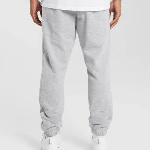 REST DAY ESSENTIALS JOGGER - Mjukisbyxor från gymshark. Heter REST DAY ESSENTIALS JOGGERS på hemsidan i färgen ”Light grey marl”. Oanvända pga köpta i fel storlek. Dem är relativt oversized i storleken. Kostar 599 från hemsidan. 