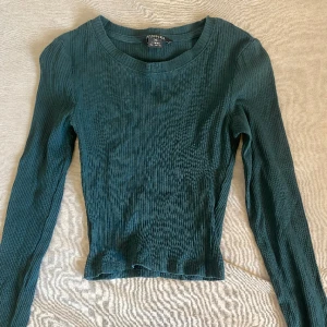 Tajt mörkgrön tröja - Säljer min jättefina tajta mörkgröna långärmade tröja från MONKI. Använts mycket men är fortfarande i bra skick och inga defekter. Säljer då den helt enkelt inte används längre. OBS! Plaggen tvättas/stryks alltid innan ifall det behövs❤️