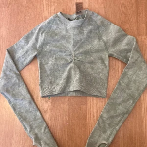 Gymshark topp  - Jätte fin långärmad gymshark topp som är lite militär grön vit färgad. Jätte fin när man gymmar. Skriv till mig om frågor och tryck gärna på köp nu❤️
