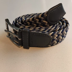 Flätat bälte  - Flätat bälte grå ljusgrå vit blå | stretch och anpassningsbar till alla storlekar | helt nytt aldrig använt | skriv om du har frågor.