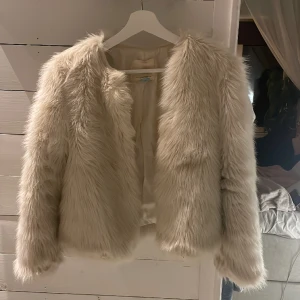 Pälsjacka - En jättefin vit beige fluff jacka i fake päls, jättebra kvalitet! Säljer pga för liten! KÖPAREN STÅR FÖR FRAKTEN📦🚚