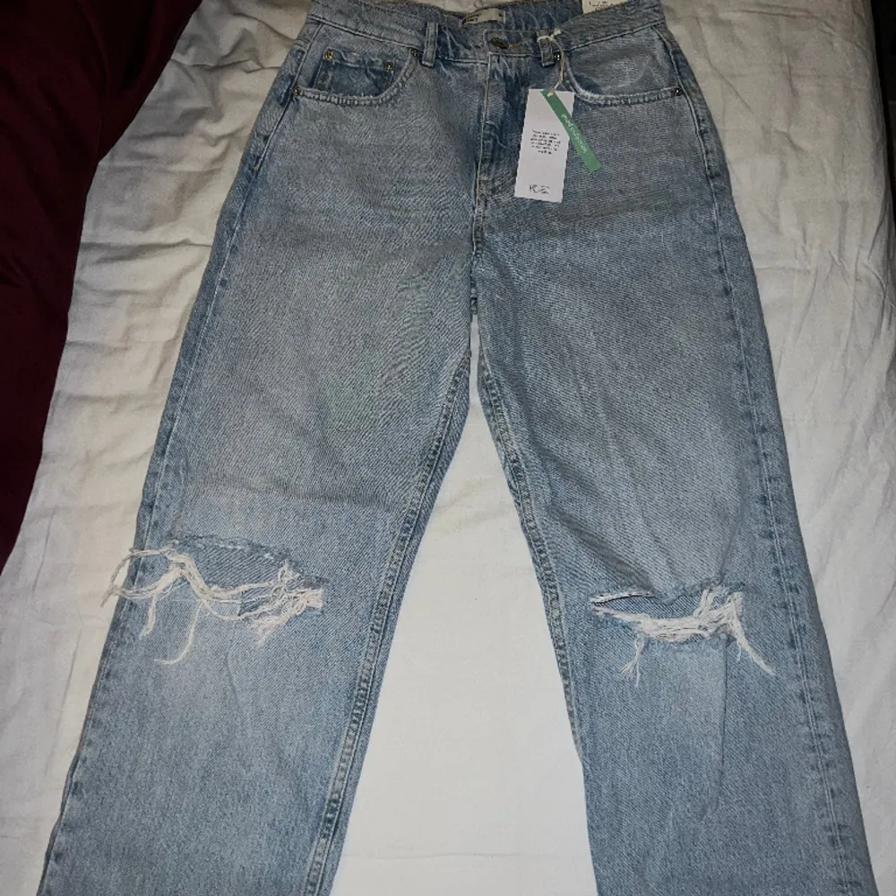 Grand med hål på knäna från Gina, storlek 36, aldrig använda. Modellen 90s High waist jeans. Nypris 600. Jeans & Byxor.