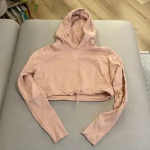Rosa croppad hoodie från gymshark. Nedre delen av ärmarna är ribbade. Använd väldigt lite