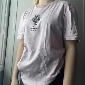 En herr t-shirt i en jättefin rosa färg med ett supercoolt tryck. Tröjan är i bra skick och trycket har inte blivit slitet.💗