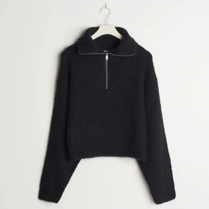 Svart stickad tröja med dragkedja  - Jag säljer en svart stickad tröja från Gina Tricot med en silvrig dragkedja. Tröjan är i fint sick och sparsamt använd❤️‍🔥 Nypris:400kr