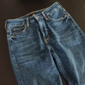 Lee flaired jeans mörkblå - Mått:  Midja- 70cm Innerben- 83cm  Ytterben- 110cm  Runt om hela höften- 94cm  Lee jeans i perfekt slick, använda fåtal gånger. Utsvängda (flaired) jenas i mörkblå färg. Midwaisted. Ordinariepris 1200kr. Väldigt fina!