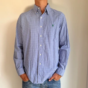 Ralph Lauren - Blårutig Ralph Lauren skjorta i storlek L. Skjortan är i fint skick utan några skavanser. Modellen är 186 cm lång. Orginalpris ca 1500 kr och mu endast 499. 
