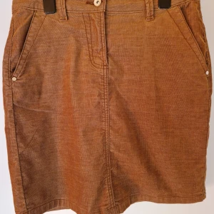 Brun kjol  - Varmtonad brun kjol, kort längd, manchester tyg, fickor