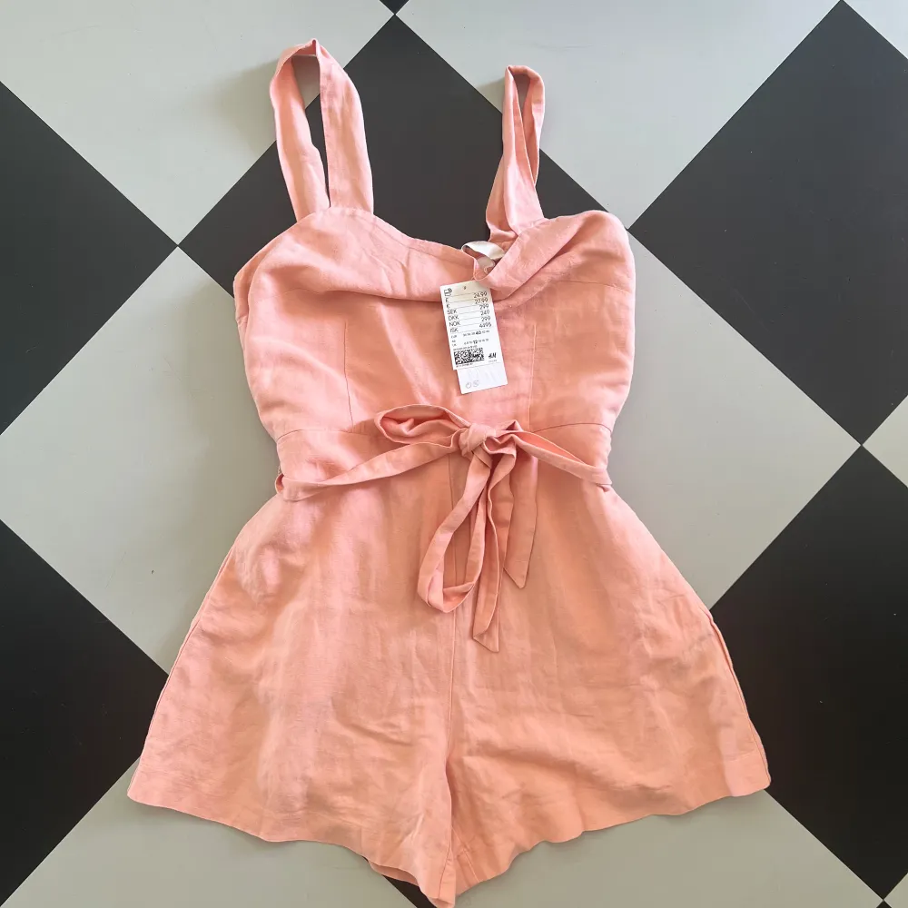 Helt ny play suit i linne från H&M. Storlek 40, passar small eller medium. Aldrig använd/ tag kvar. Slut i butik/online. Samfraktar.. Klänningar.