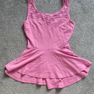 En jättesöt rosa topp/linne ifrån ginatricot😍 Den är rosa med spets och en liten volangkjol💞I storlek S! Hör av er om ni har några frågor eller är intresserade!