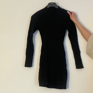 Stickad Kofta/klänning - Fungerar utmärkt som en kofta på vinter men använt även som klänning med stövlar till. Klänningen är mönstrad och finns en öppning vid ryggen. Dock är den lite see through. 