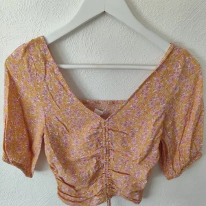 Somrig blus - Blommig blus med dragsko. Nyskick, väldigt lite använd. Hör av er vid frågor🩷