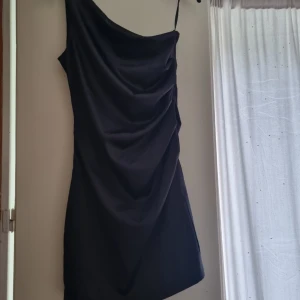 Svart satin klänning  - Svart kort satinklänning. I jätte bra skick och aldrig använd. 