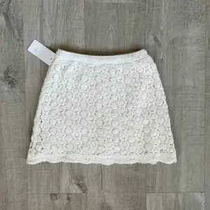 Säljer denna fina vita virkade kjol. Passar XS/S. Aldrig använd. Inbyggda shorts i. 