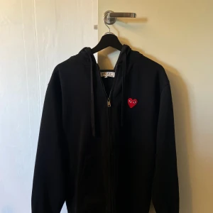 Cdg zip Hoodie  - Hej, jag säljer en stilren Cdg zip Hoodie. Hoodies skick är 10/10 då den är sparsamt använd och inte har några defekter. Nypris är ungefär 3000kr. Vid frågor och funderingar är det bara att höra av sig. Pris går att diskutera vid en snabb affär! 