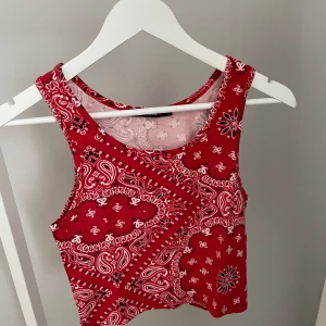 Topp från BikBok - Röd topp med mönster från BikBok i storlek M men passar även S. Aldrig använd så är i nyskick!✨ Köparen står för frakten, kan mötas upp i Kalmar!