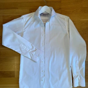 Vit skjorta - skräddarsydd för lång och smal kille - Skräddarsydd skjorta av George Bush seniors skräddare. Extreme cutaway. Storlek 44-46 som passar en lång och smal person 180-190 cm. Finns massor med skjortor i vitt och blått, bara att höra av sig. Finns cirka 20 stycken. 